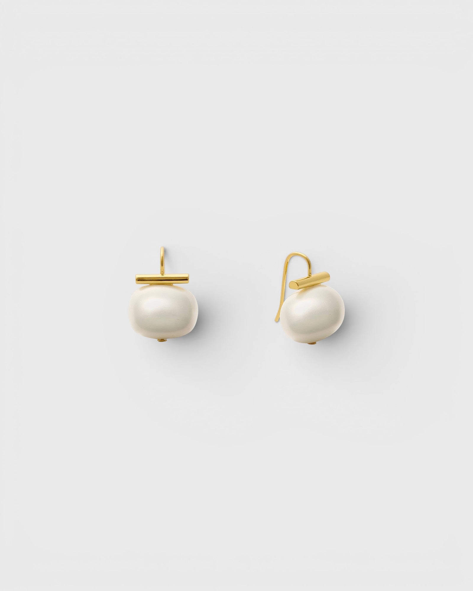 JONES + CO statement pebble pearl earrings in white with 14k gold over brass handmade ear wires on a light background.