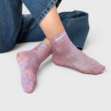 JONES + CO pink laminated net socks with a ribbed texture worn on a model in blue jeans.