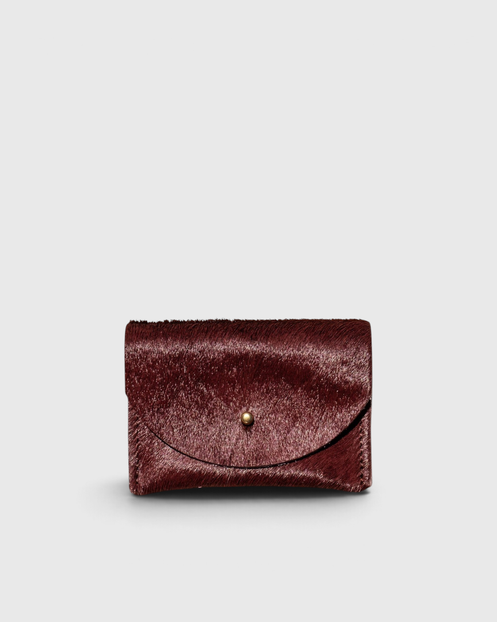 JONES + CO plum cowhide cardholder with a solid brass fastener, featuring a compact design for cards and cash.