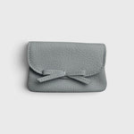JONES + CO Provence Blue leather petite case with a front flap, knotted bow detail, and hidden magnetic closure.