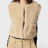 JONES + CO reversible short vest in oatmeal beige faux fur, featuring a collarless design and soft wool blend texture.
