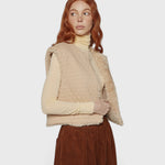 JONES + CO reversible short vest in oatmeal beige with quilted wool blend and soft faux fur lining on a model