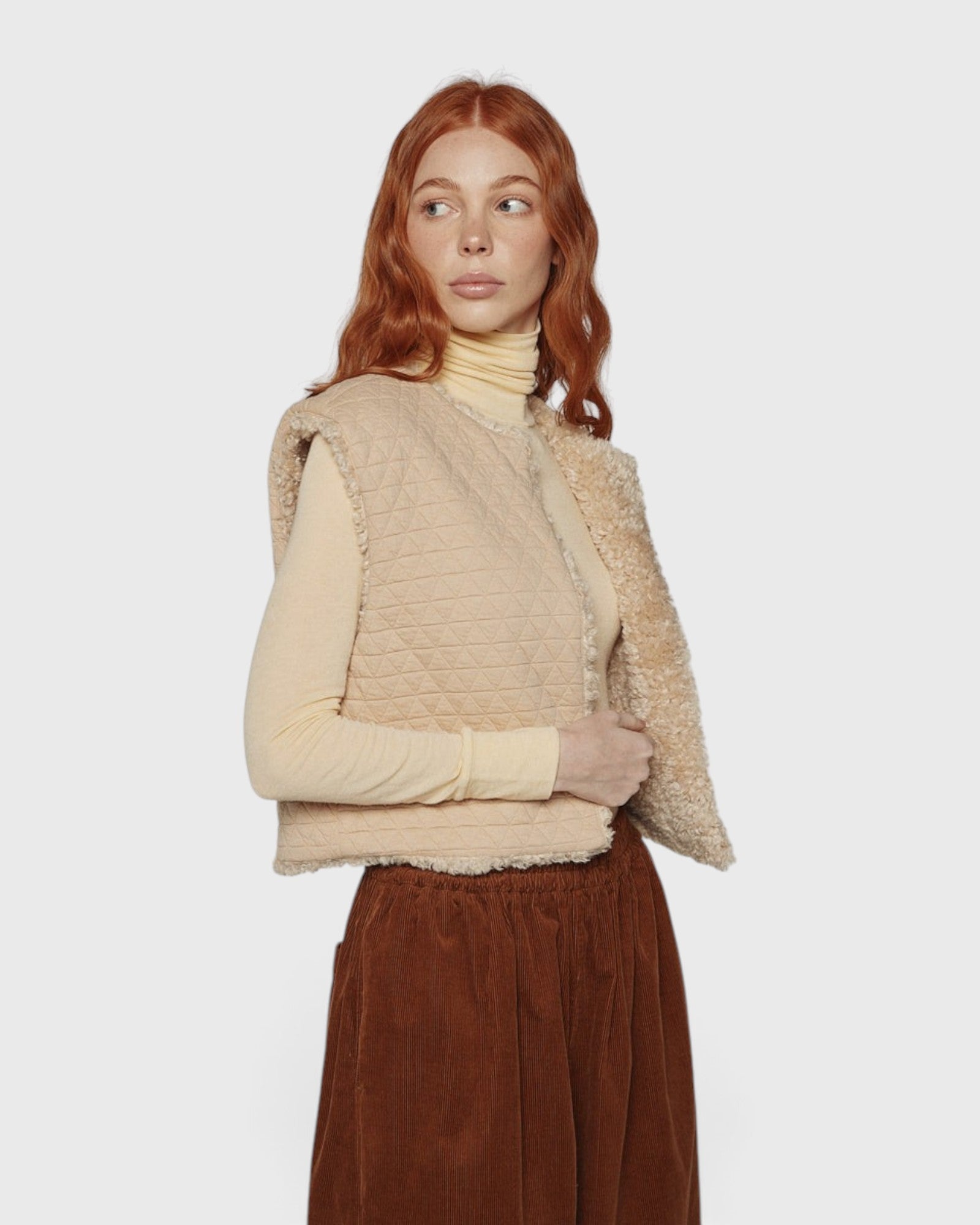 JONES + CO reversible short vest in oatmeal beige with quilted wool blend and soft faux fur lining on a model