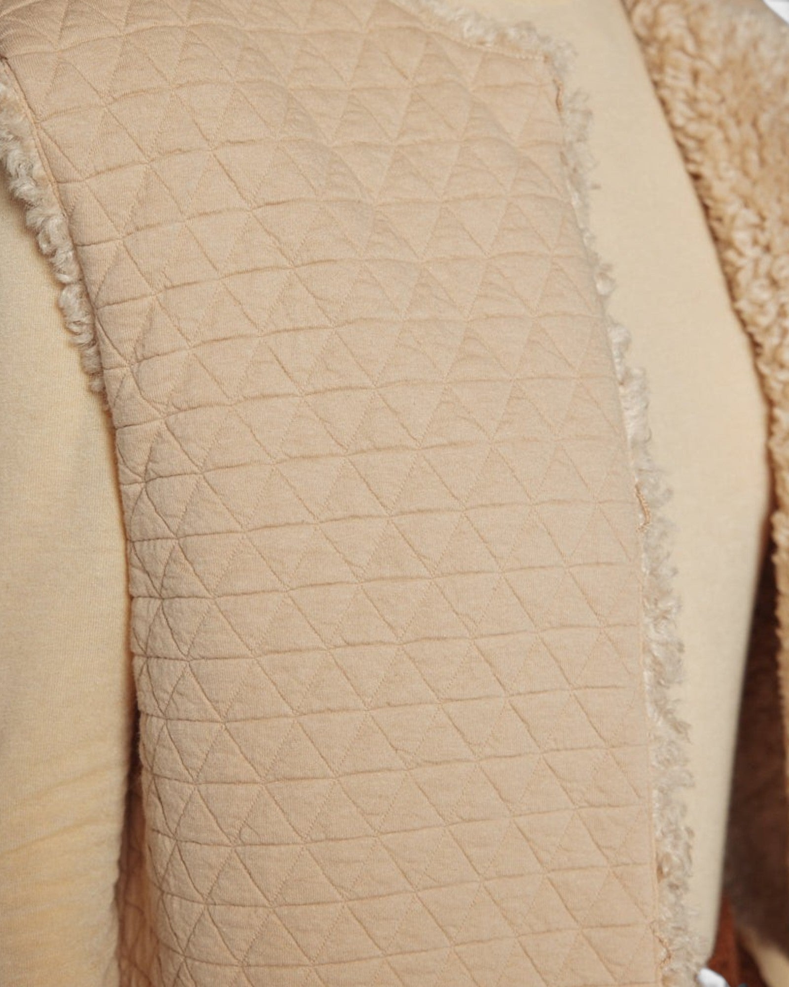 JONES + CO reversible short vest in oatmeal beige featuring a quilted wool blend side and soft faux fur texture.