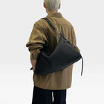 JONES + CO Rider M black soft calf leather shoulder bag with adjustable belt strap worn crossbody by a model