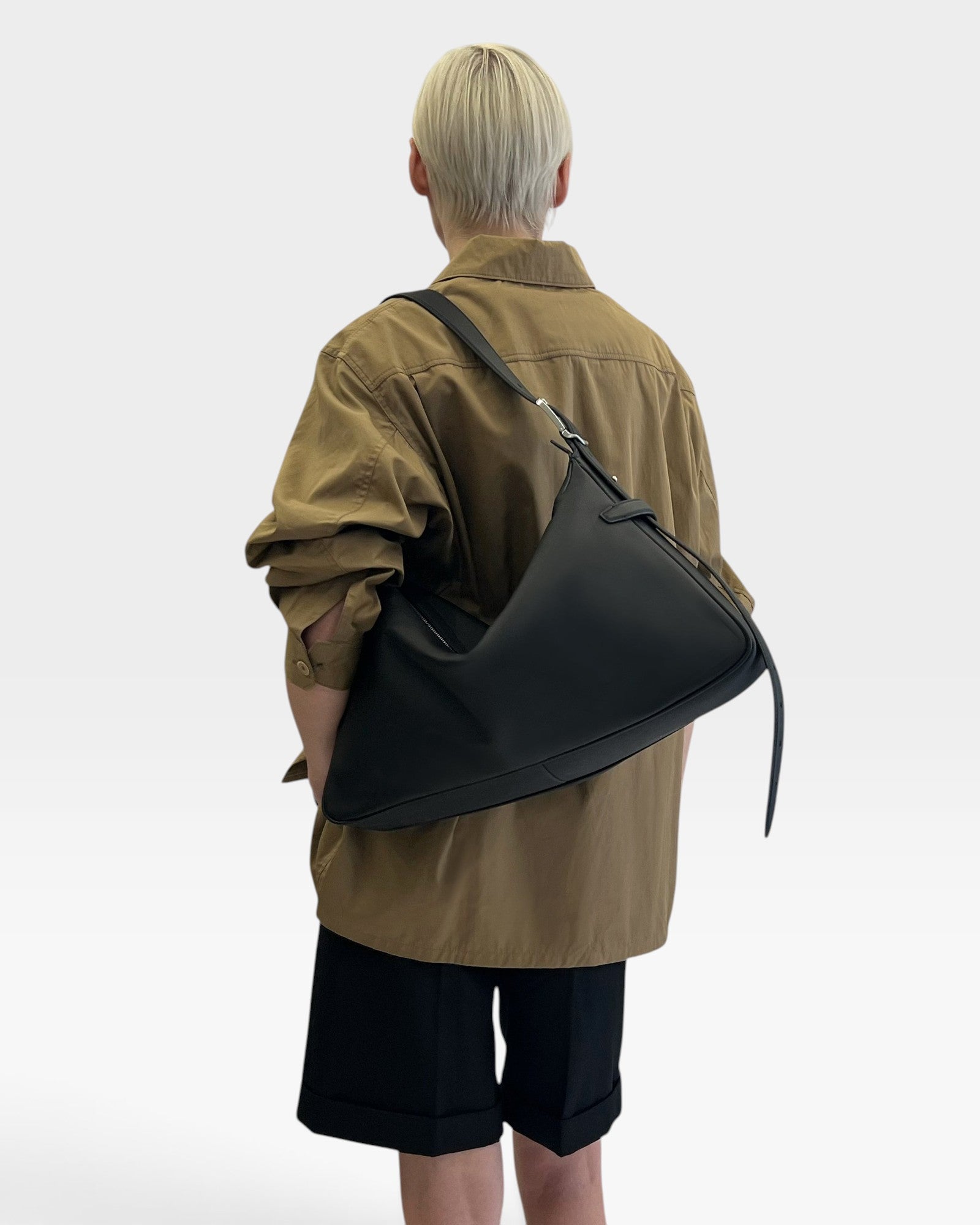 JONES + CO Rider M black soft calf leather shoulder bag with adjustable belt strap worn crossbody by a model