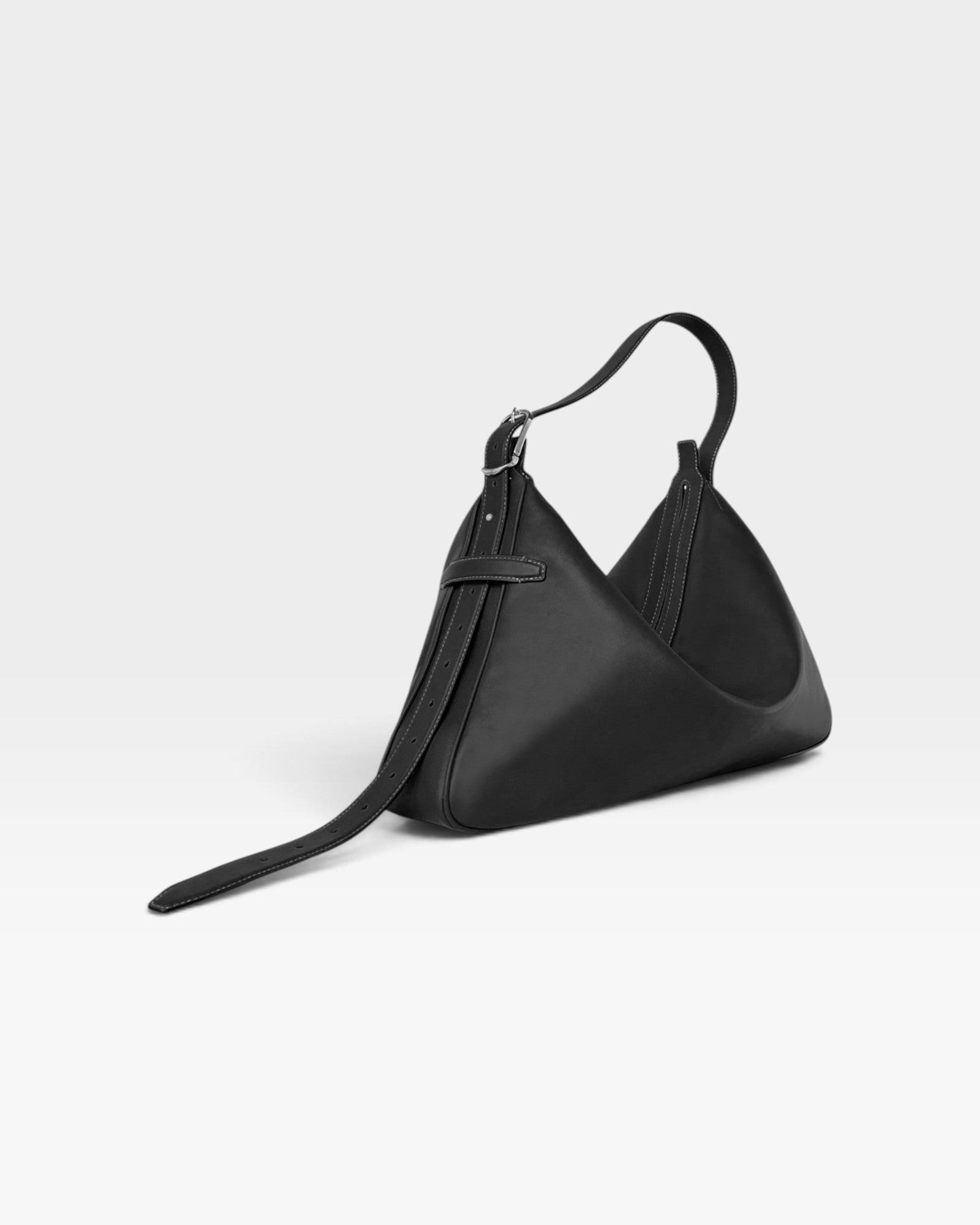JONES + CO Rider M black calf leather shoulder bag with a unique skateboard rink shape and adjustable belt strap.