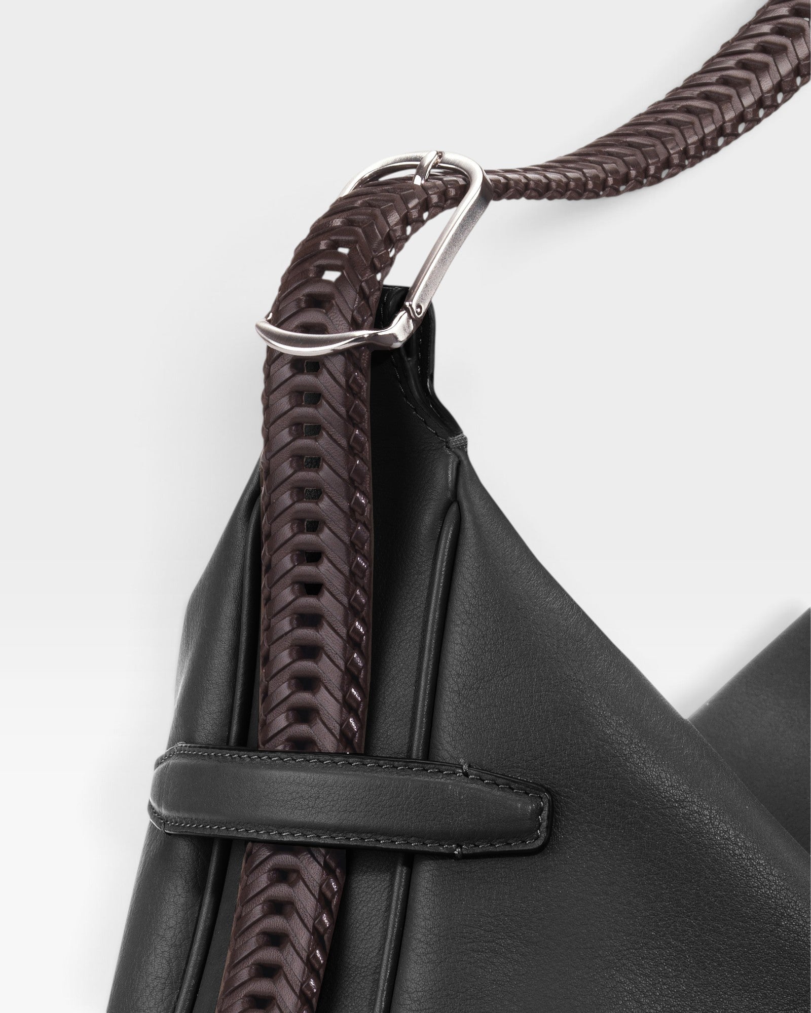 JONES + CO Rider M Elche black leather bag with a unique hand-braided dark brown strap and silver hardware detail.