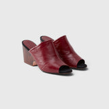 JONES + CO Rachel Comey scarlet leather wedge mules with an angular peep toe and sculptural clog-inspired heel.