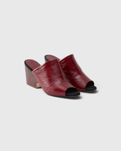 JONES + CO Rachel Comey scarlet leather wedge mules with an angular peep toe and sculptural clog-inspired heel.