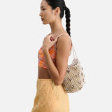 Model wearing a JONES + CO silver leather macrame mini web bag with bamboo beads over her shoulder
