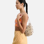 Model wearing a JONES + CO silver leather macrame mini web bag with bamboo beads over her shoulder