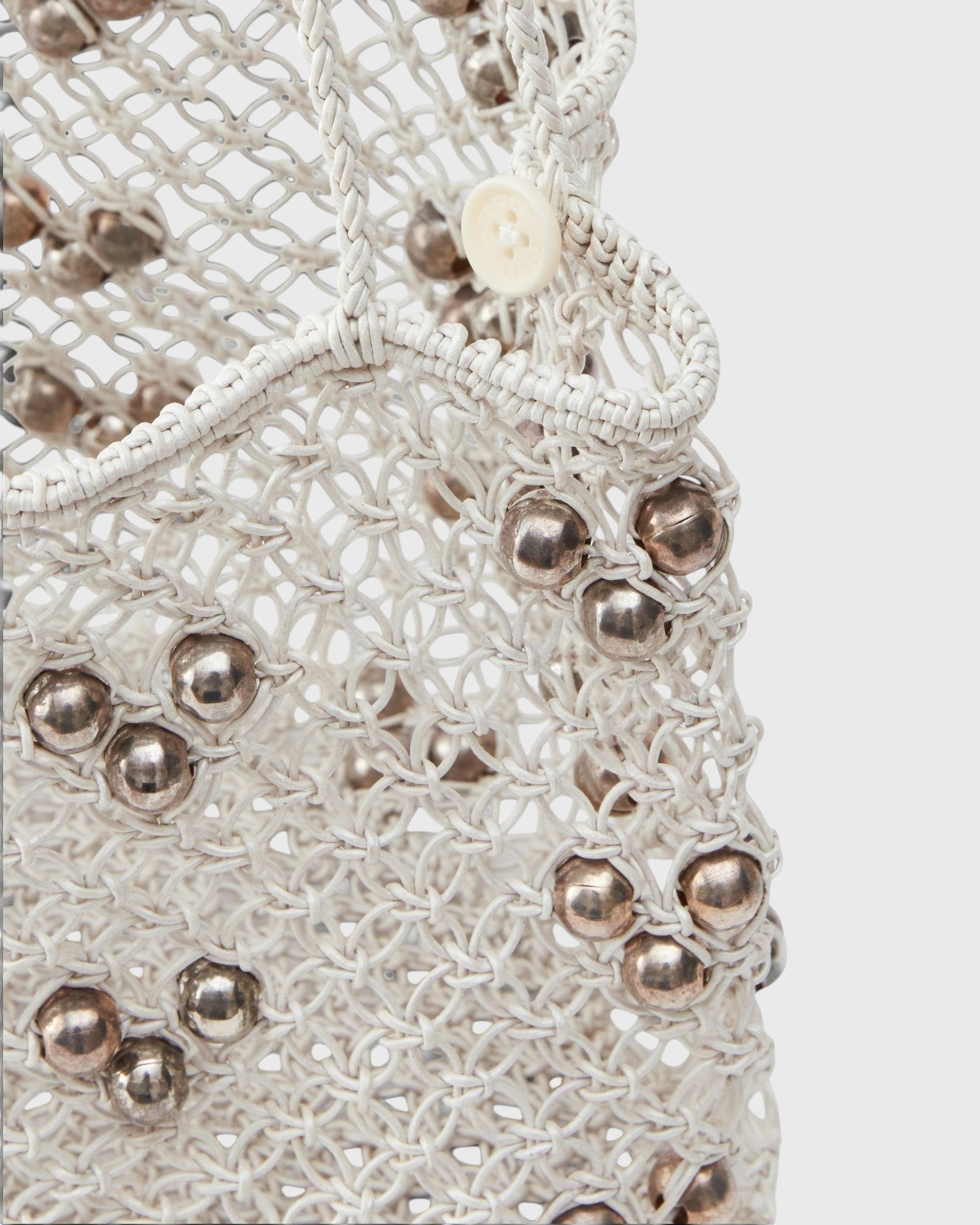 JONES + CO Mini Web Bag in silver featuring intricate macrame leather weaving and metallic bamboo bead details.