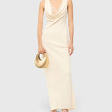 JONES + CO STAUD Good Night Moon evening bag in polished gold held by a model in a cream cowl-neck maxi dress