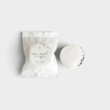 JONES + CO Sweet Dreams shower steamer in white packaging next to a single round lavender and vanilla scented tablet.