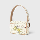 JONES + CO Tommy beaded shoulder bag in cream with a dog walk motif, vegan leather piping, and flap closure.