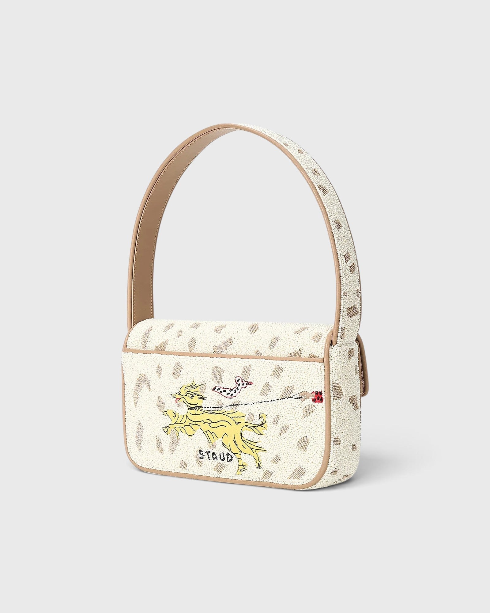 JONES + CO Tommy beaded shoulder bag in cream with a dog walk motif, vegan leather piping, and flap closure.