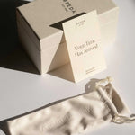 JONES + CO branded watch packaging including a beige gift box, a note card, and a soft drawstring storage pouch.