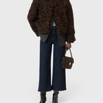 JONES + CO Wera dark blue high-waisted wide-leg cropped stretch denim jeans worn with a brown curly faux fur jacket