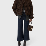 JONES + CO Wera dark blue high-waisted wide-leg cropped stretch denim jeans worn with a brown curly faux fur jacket
