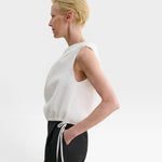 JONES + CO white one-shoulder Farfalla top in Italian Foam fabric with a draped silhouette and drawstring waist.