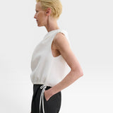 JONES + CO white one-shoulder Farfalla top in Italian Foam fabric with a draped silhouette and drawstring waist.