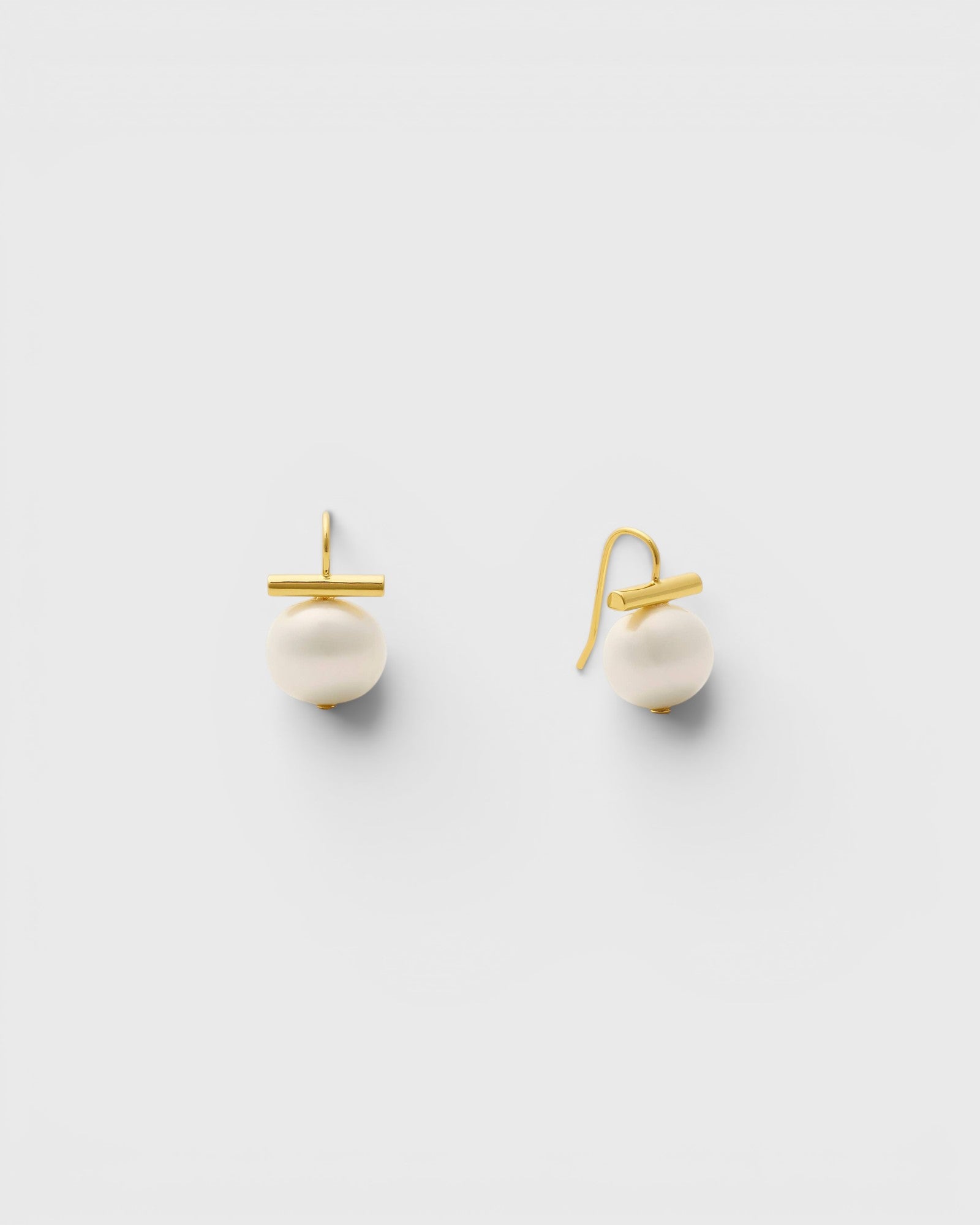 JONES + CO white pebble pearl drop earrings with 14k gold over brass bar and handmade ear wires on white background