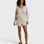 Model wearing JONES + CO whitecap grey French terry lounge shorts with an elastic waistband and raw edge hem.