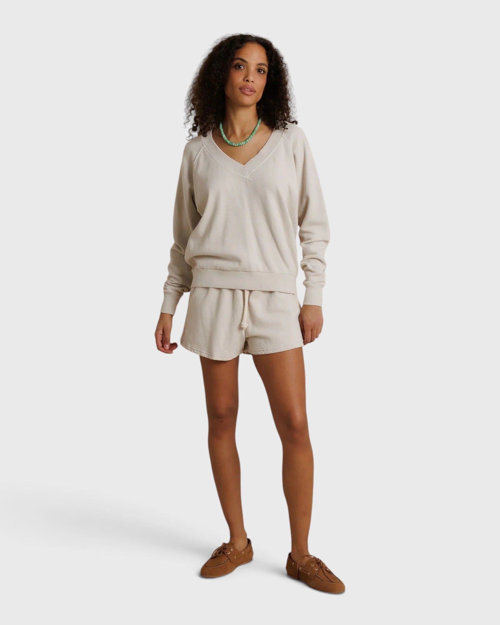 Model wearing JONES + CO whitecap grey French terry lounge shorts with an elastic waistband and raw edge hem.