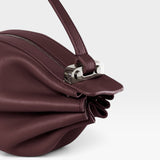 JONES + CO Bon-Bon wine-colored calf leather handbag featuring a pleated design and polished palladium brass clasp.