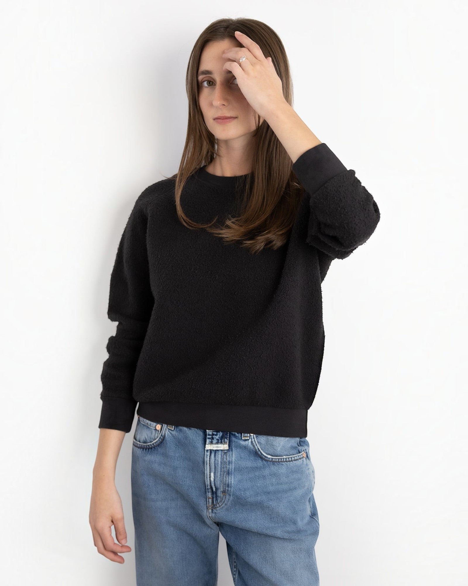 Model wearing a JONES + CO Ziggy sweatshirt in vintage black with a textured fleece finish and ribbed cuffs.