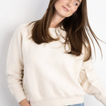 JONES + CO Ziggy sweatshirt in sugar cream textured fleece with a crew neck and cropped sleeves worn with blue jeans