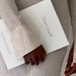 Person holding a book titled 'Reset Guide' with a neutral background