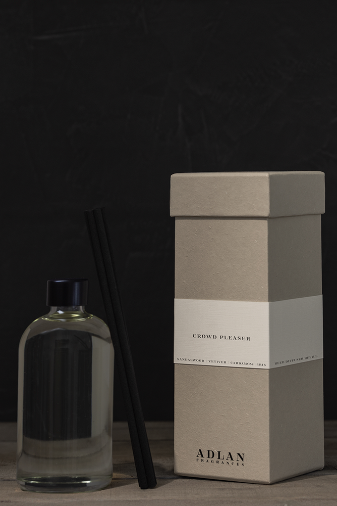 A diffuser bottle and packaging box on a dark surface with a black background
