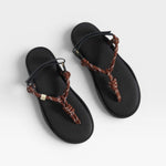 Black sandals with brown braided straps on a white background