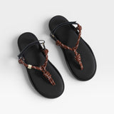 Black sandals with brown braided straps on a white background