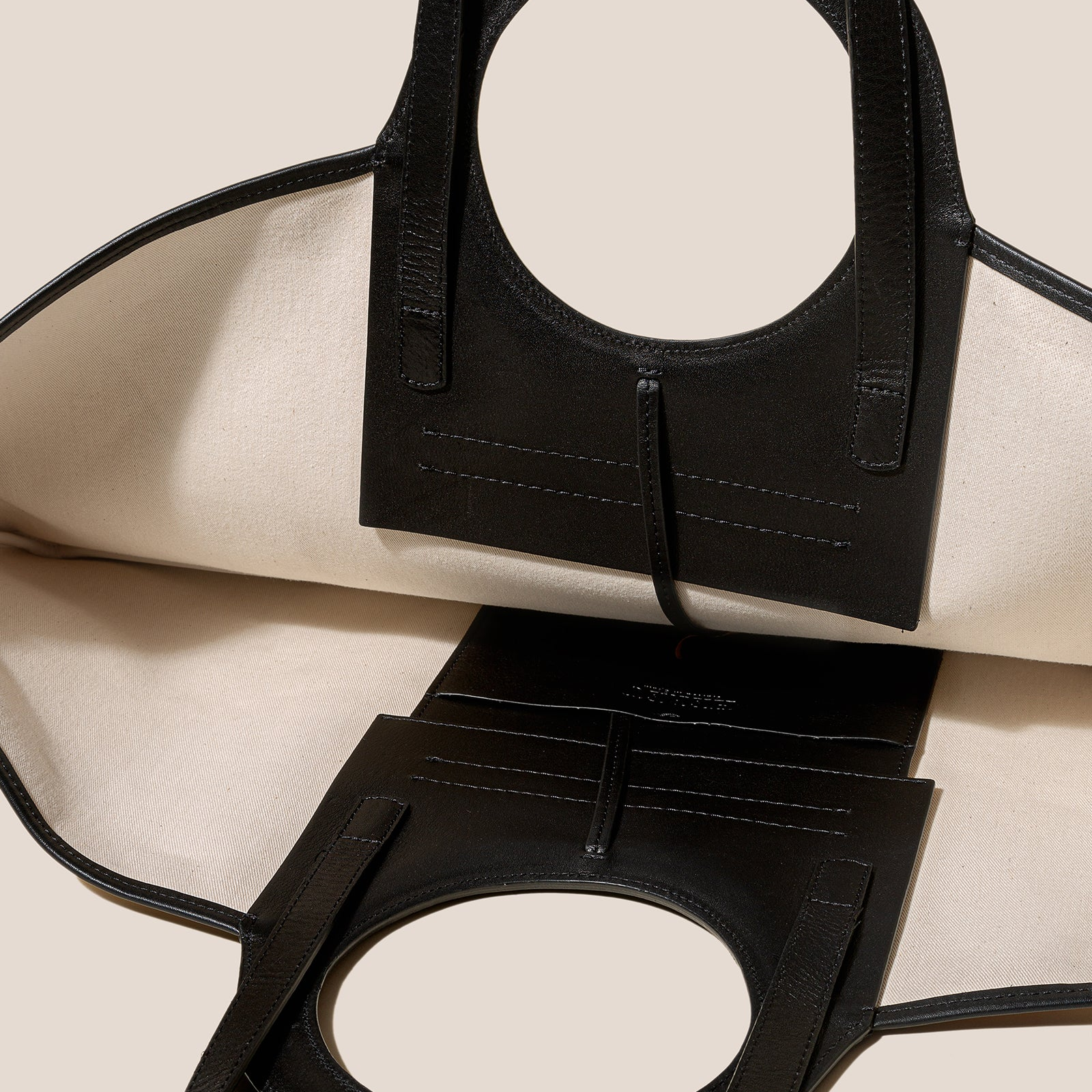 Black leather handbag with a beige background