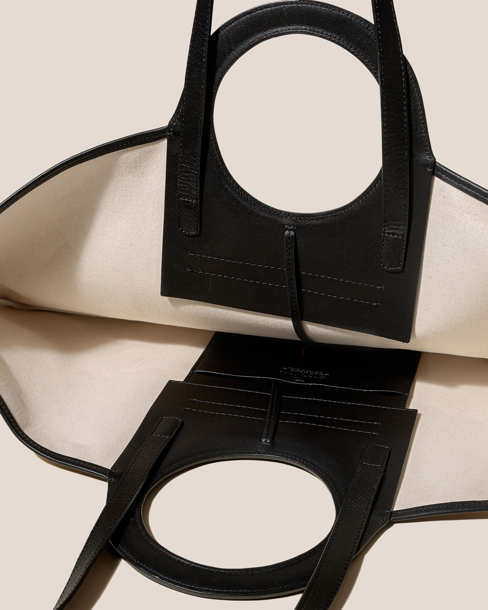 Black leather handbag with a beige background