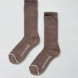 Pair of brown socks with white trim on a light gray background