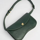 Green leather bag with a gold clasp on a light gray background