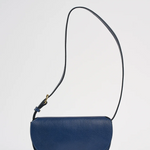Blue leather crossbody bag on a light gray background