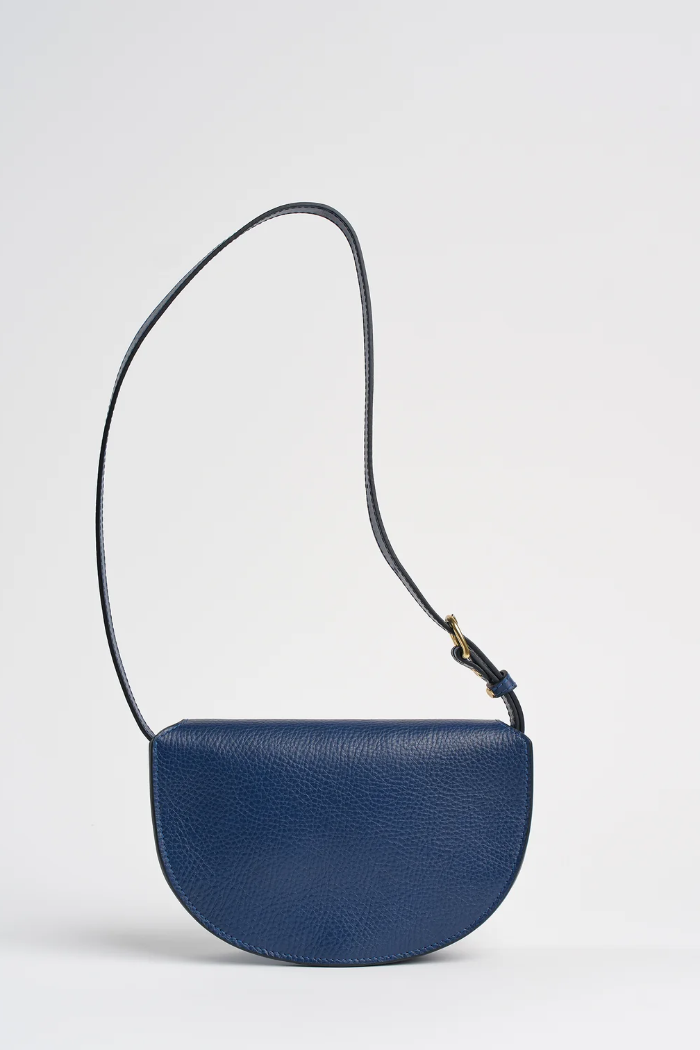 Blue leather bag with a strap on a light gray background