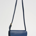 Blue handbag with a strap on a light gray background