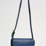 Blue handbag with a strap on a light gray background