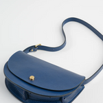 Blue handbag with a strap on a light gray background