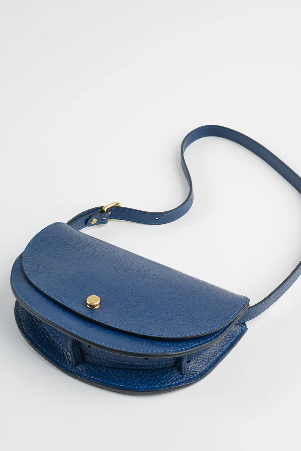 Blue handbag with a strap on a light gray background