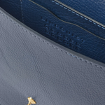 Close-up of a blue leather handbag with a gold logo on a white background