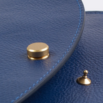 Close up of a blue leather purse with gold hardware