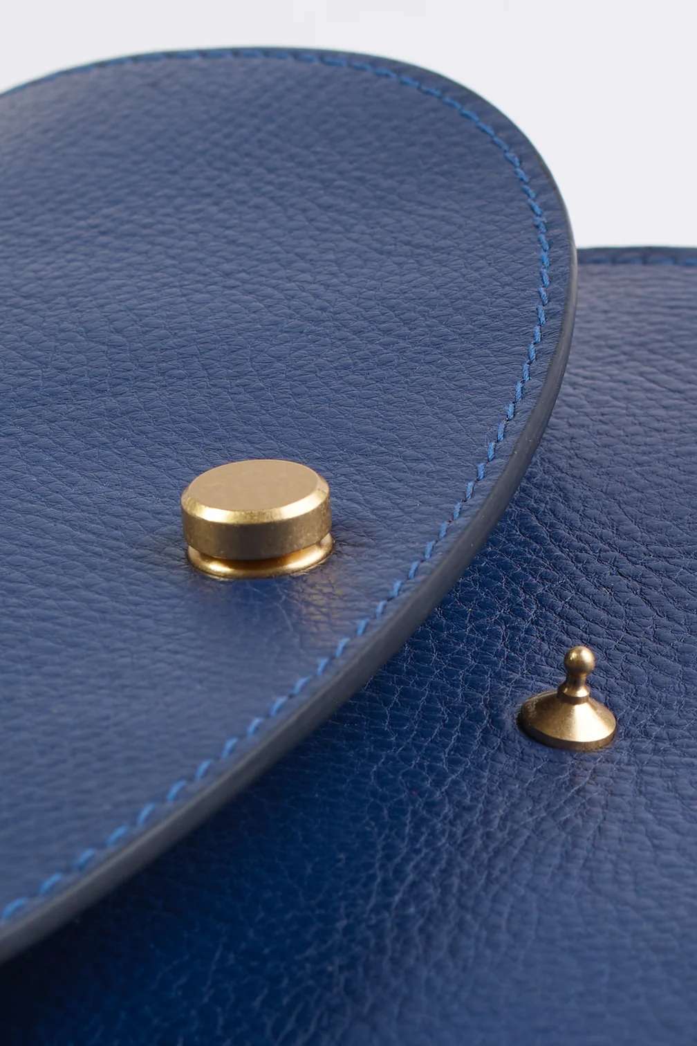 Close up of a blue leather purse with gold hardware