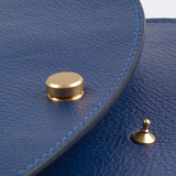 Close up of a blue leather purse with gold hardware